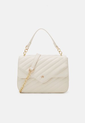Crème-kleurige gewatteerde handtas met gouden kettingdetail en een enkele bovenhandgreep op een effen witte achtergrond.
