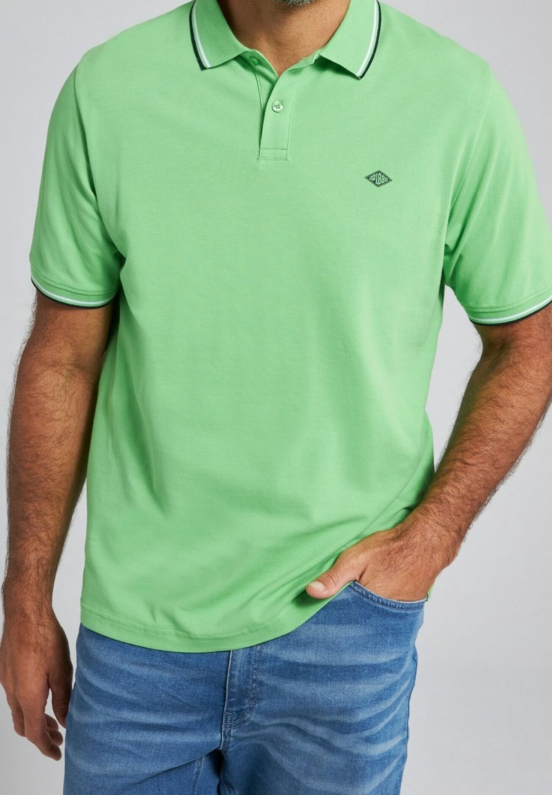 Polo vert avec col, patte à deux boutons et petit logo. Présente des rayures contrastées vert foncé sur le col et les manches.