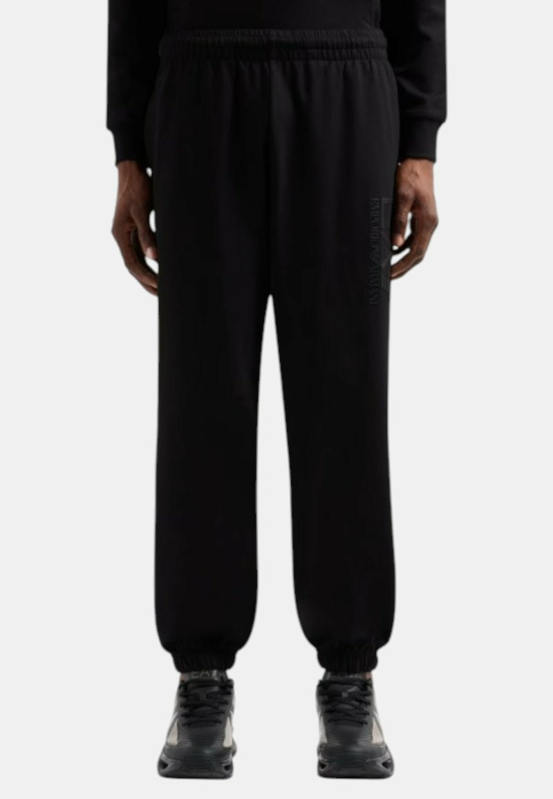Pantaloni della tuta neri realizzati in tessuto morbido, dotati di una vita elastica, polsini a costine e un dettaglio logo stampato sul lato.