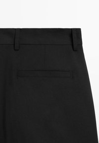 Schwarze Hose mit glatter Textur, ausgestattet mit einem Standardbund und einer kleinen Gesäßtasche. Schlichtes Design ohne sichtbare Verzierungen oder Muster.