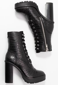 Czarne botki za kostkę o fakturze krokodyla, z przodem na sznurowanie, bocznym zamkiem błyskawicznym i masywnym czarnym obcasem. Wytrzymała gumowa podeszwa.