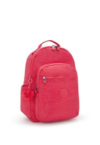 Rosa nylonryggsäck med ett huvudfack, framficka, justerbara remmar och en fluffig apa som nyckelring. Texturerad yta.