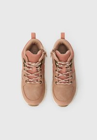 Rózsaszín sportcipők hálós és szintetikus bőr felsőrésszel, kerek orral, perforált részletekkel és lapos fűzőkkel. A saroknál húzófül található.