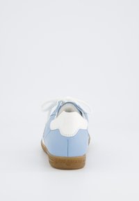 Světle modré kožené tenisky s bílými detaily, kulatá špička a béžová gumová podrážka. Mají šněrování a razítkované logo na patě.