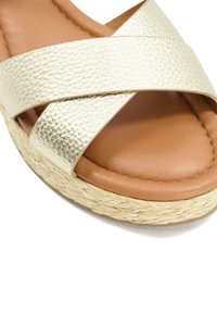 Sandale glissière en cuir synthétique doré avec des brides croisées, dotée d'une semelle intérieure rembourrée marron et d'une semelle en style espadrille tissée.