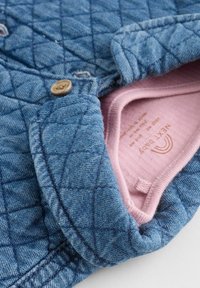 Gequilted denimjacket in blauw met een roze binnenvoering. Beschikt over een kraag, knoopsluiting en een gestructureerde stof in een getailleerde snit.