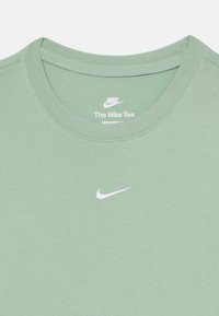 T-shirt Nike vert menthe avec un col rond, en tissu coton doux, et un petit logo Nike blanc cousu sur la poitrine.