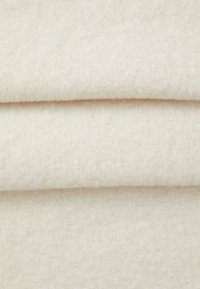 Heledbeige villakangas, pehme tekstuur, veidi pehme viimistlus. Klappitud, kus on nähtavad kiud ja ühtlane, sile pind.
