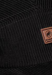 Schwarze Cordhut mit vertikalen Rippungen und einem braunen Lederpatch mit einem Elefantenlogo. Robuste Nähte entlang der Nähte.