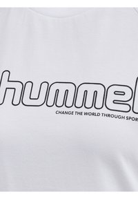 Bílý bavlněný tričko s černým, výrazným logem "hummel" a textem "ZMĚŇTE SVĚT PROSTŘEDNICTVÍM SPORTU" v jednoduchém písmenovém písmu sans-serif.