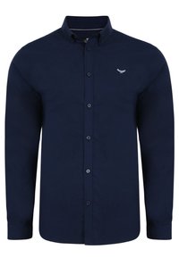 Camisa de botón de manga larga azul marino con un cuello clásico, que presenta un pequeño logotipo en el lado izquierdo del pecho y una textura de tela suave.
