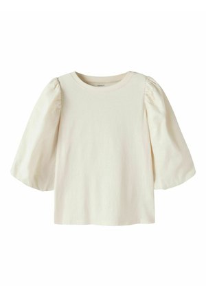 Blouse longue couleur crème avec manches bouffantes et col rond, conçue pour les enfants.