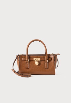 Sac à main en cuir marron avec deux poignées supérieures, une bandoulière amovible et une fermeture à serrure dorée sur le devant.