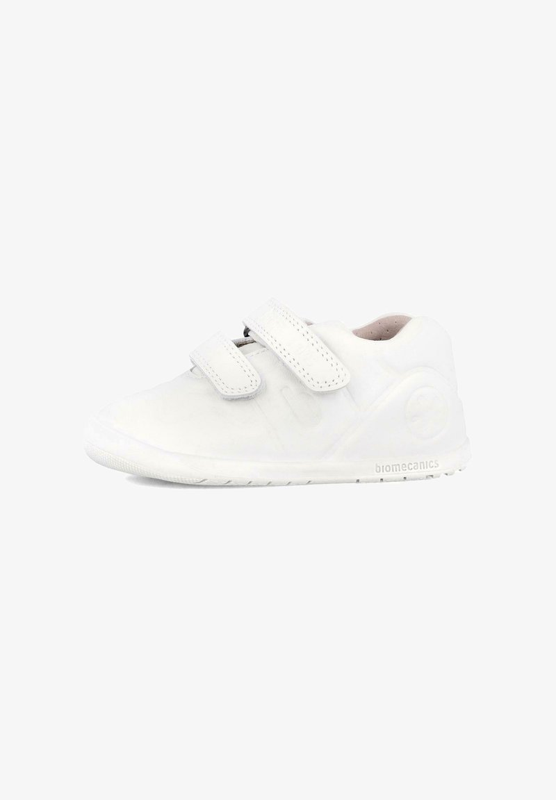 Zapatilla blanca con una textura suave, correas de velcro, punta redondeada y suela de goma. Cuenta con un logotipo en el lateral y un diseño minimalista.