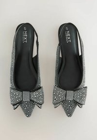 Juodi slingback batai su smailiais nosiniais, papuošti baltais perlais ir dideliu kaspinu priekyje. Lygus vidinis pamušalas.