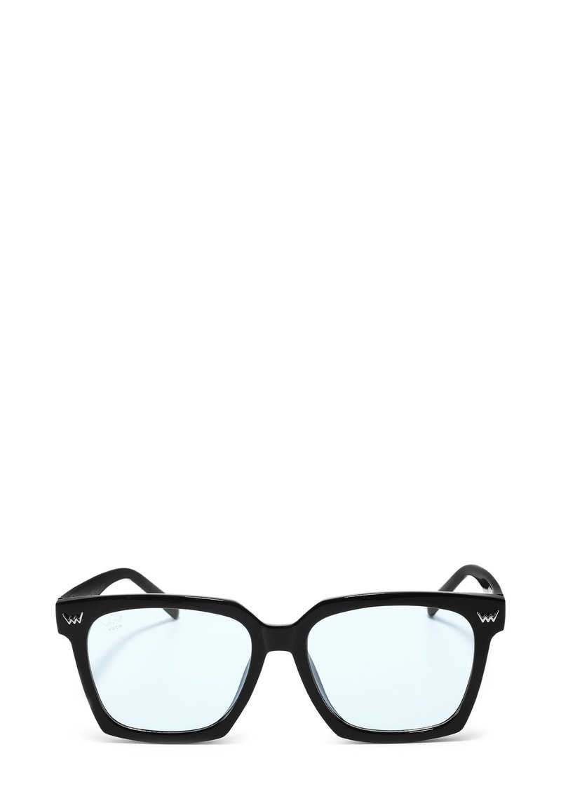 Černé sluneční brýle ve čtvercovém tvaru s průhlednými skly, silnými plastovými rámy a ostrým designem. Na spánku se nachází logo.
