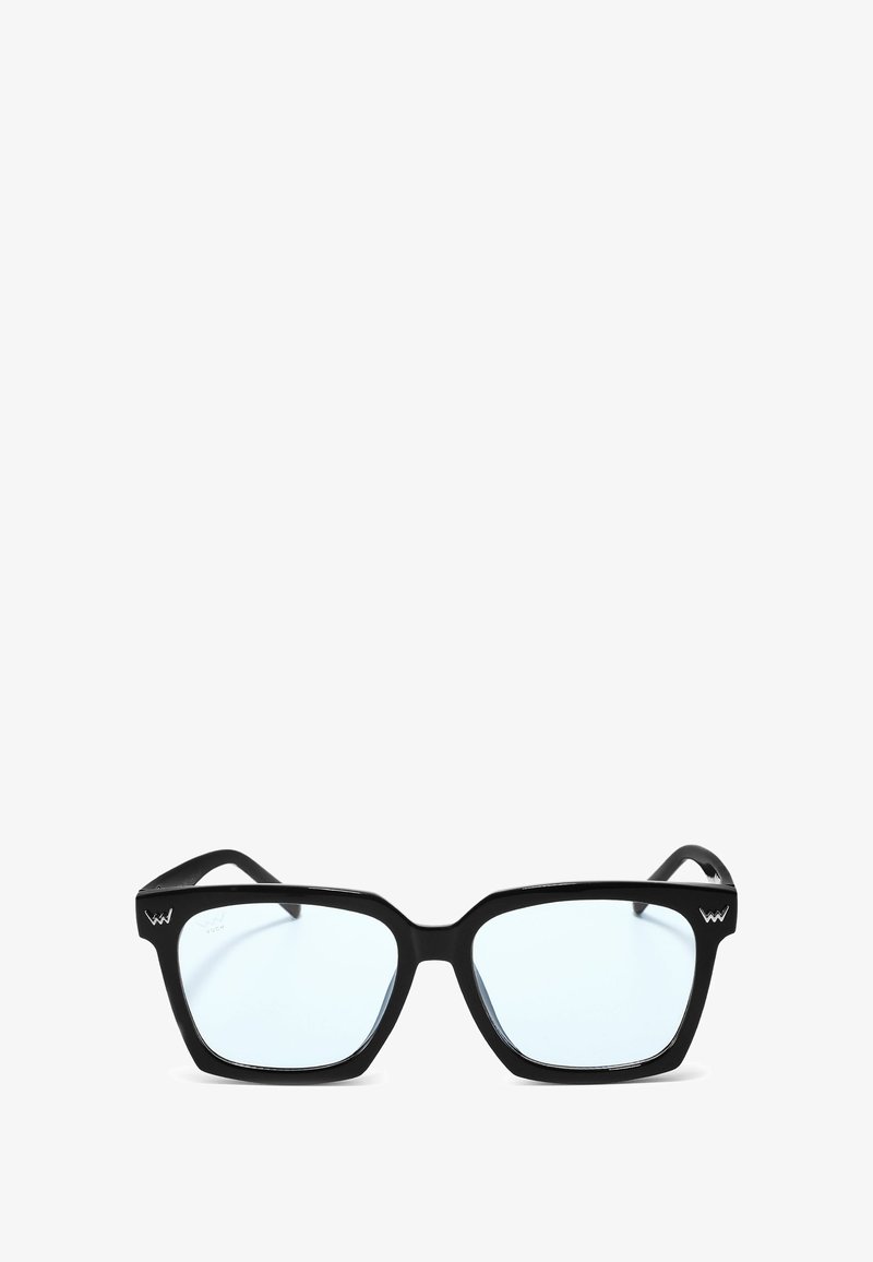 Černé sluneční brýle ve čtvercovém tvaru s průhlednými skly, silnými plastovými rámy a ostrým designem. Na spánku se nachází logo.
