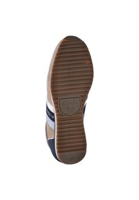 Zool van een sneaker met rubberen materiaal, voorzien van een geribbeld patroon, tan kleur met marineblauwe accenten, en een label met de tekst "Australian Since 1949".