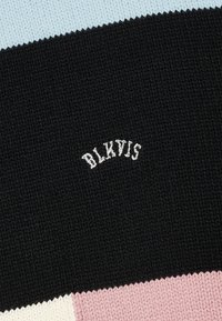 Pezzo di tessuto in maglia a patchwork con sezioni in azzurro chiaro, nero, rosa e crema. Presenta la scritta "BLKVIS" ricamata in bianco sulla sezione nera.