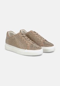 Sneaker beige con accenti borchiati e suola in gomma bianca, caratterizzati da una tomaia texture e chiusura tradizionale con lacci.