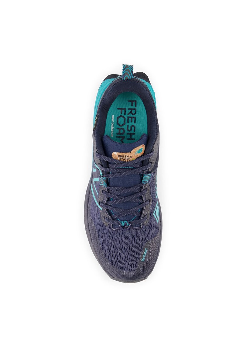 Zapatilla de running azul marino con parte superior de malla, acentos turquesa y suela de goma. Cuenta con cordones, etiqueta y marca "Fresh Foam" en el interior.