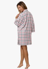 Koszula nocna w kratę w odcieniach różu, szarości i bieli; lekki materiał; długie rękawy; kołnierz z wycięciem; boczne rozcięcia dla swobody ruchów.