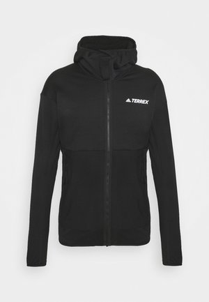 Veste noire Adidas Terrex à fermeture éclair avec capuche, manches longues et deux poches latérales zippées, présentée sur un fond uni.
