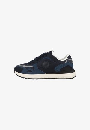 Zapatilla deportiva azul marino y negra con suela blanca, cordones delanteros, detalles de malla y ante, y logotipo de la marca en el panel lateral.
