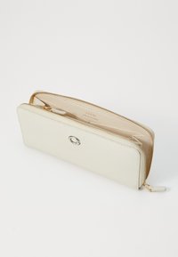 Portefeuille en cuir beige clair avec une surface texturée, quincaillerie en argent et fermeture zippée. L'intérieur dispose de plusieurs emplacements pour cartes et compartiments.
