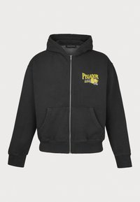 Felpa nera con zip in cotone, con logo giallo stampato sul petto sinistro e tasche frontali. Tessuto morbido con polsini a coste.