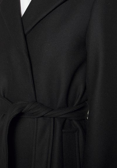 Black coat with a textured surface, featuring a wrap design and a knotted sash belt. Includes side pockets and structured lapels.