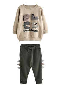 Felpa beige con applicazioni di dinosauri e testo "DINO.ROAR"; pantaloni della tuta grigi e verde chiaro con punte laterali. Tessuto morbido, design casual.