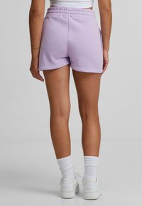 Lavendel bomullsshorts med elastisk midja, sidofickor och l�ös passform. Stylad med vita sneakers och ankellånga strumpor.