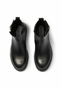 Czarne botki za kostkę wykonane z gładkiej skóry z zaokrąglonym noskiem i teksturowaną czarną podeszwą. Posiadają boczny zamek i pętelkę do łatwego zakładania.