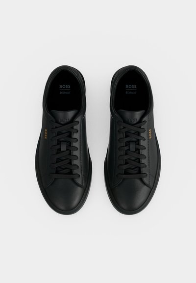 Paire de baskets basses en cuir noir à lacets avec logo BOSS sur le côté et semelles intérieures rembourrées marquées Ortholite, vues de dessus.