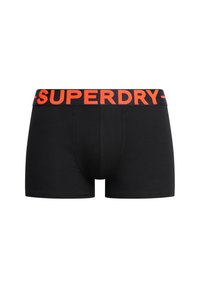 Boxers en coton noirs avec une ceinture élastique rouge portant le texte "SUPERDRY". Le design a une coupe ajustée et une texture lisse.