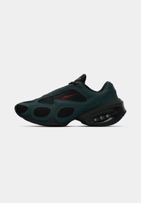 Tamnozeleni i crni Nike tenisky s crvenim swooshom, mrežastim panelima i vidljivim jastučićem za petu, prikazani u bočnom profilu na bijeloj pozadini.