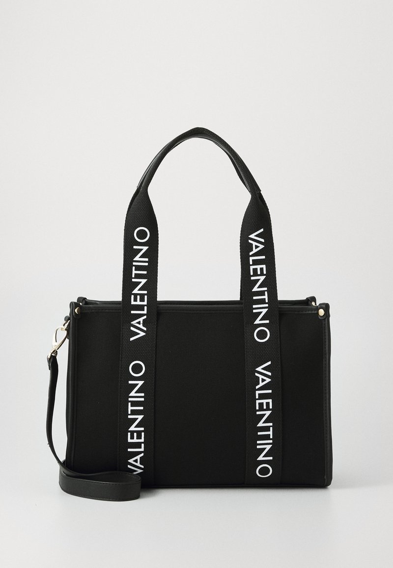 Sac à main rectangulaire noir avec doubles poignées en tissu ornées de logos Valentino blancs et une bandoulière ajustable.