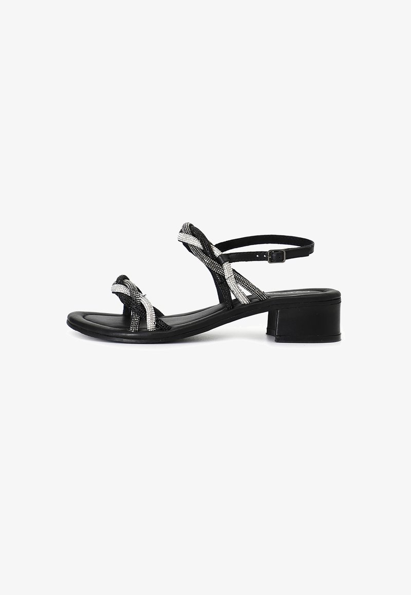 Sandal nero con cinturini intrecciati e dettagli in argento. Tacco basso e cinturino regolabile alla caviglia. Texture liscia e design con punta aperta.