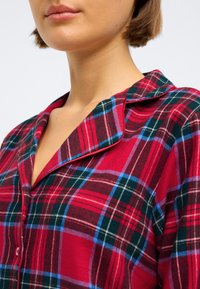 Rød rutete pysjamasoverdel med blå og grønne detaljer, med notched krage og knapplukking, laget av mykt bomullsmateriale.