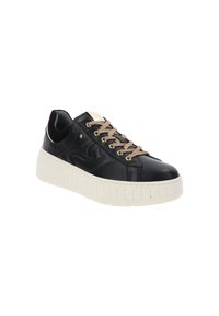 Baskets noires avec une épaisse semelle beige et des lacets, œillets dorés et un logo embossé subtil sur le côté.