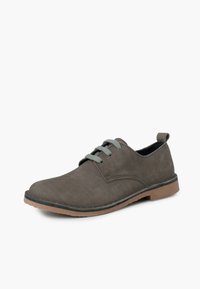Scarpa in suede grigia con punta arrotondata, cinque occhielli per la chiusura con lacci e suola in gomma marrone. Presenta una linguetta sul tallone.