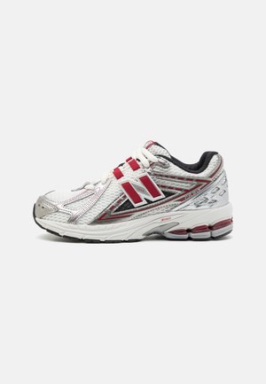 Biało-czerwony but do biegania New Balance 1906R z cholewką z siateczki, wyściełaną podeszwą i czarną wyściółką wewnętrzną, pokazany z boku na białym tle.