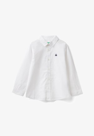 Bílá košile s dlouhým rukávem na knoflíky, límeček a malým černým vyšívaným logem na levé straně hrudi.