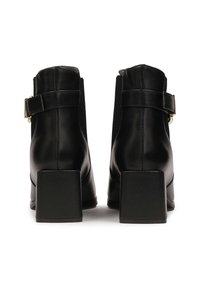 Black leather ankle boots with a smooth finish, featuring elastic side panels, a decorative buckle, and wide block heels.