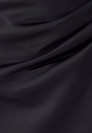 Tela de satén negra con superficie lisa y brillante, y pliegues suaves y fluidos que crean sombras y reflejos suaves.