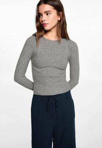 Harmaa ribbattu pitkähihaine paita, jossa on tiukka siluetti ja avara kaula-aukko, yhdistettynä tummansinisiin naruhaalareihin.