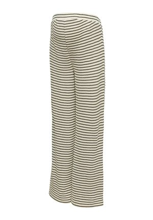 Pantalon large couleur crème à rayures noires en zigzag horizontales et taille haute.