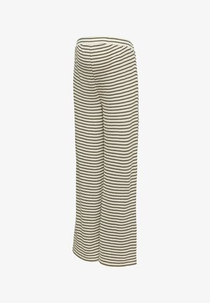 Pantalon large couleur crème à rayures noires en zigzag horizontales et taille haute.