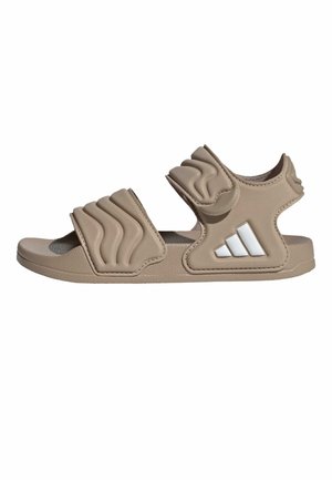 Beige sandaal met open teen, twee gevoerde verstelbare banden en een wit logo met drie strepen aan de zijkant.